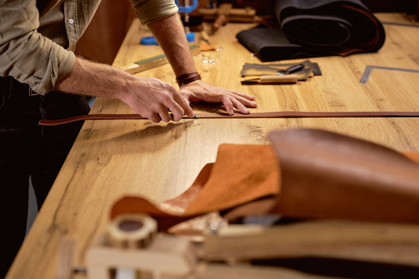 skilled artisan Burnishing the Short Edges of belt, close up cropped side view shot - Фото, изображение