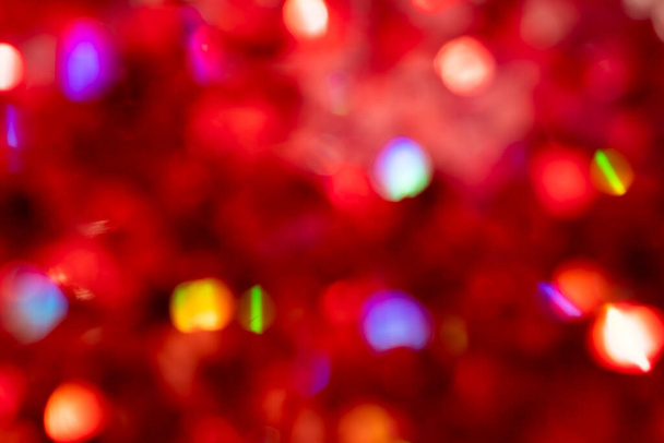 Bokeh multicolore sur fond rouge flou. Bokeh multicolore sur fond rouge flou. Fête arrière-plan peut être utilisé pour les cartes postales pour le Nouvel An, Noël, Saint Valentin. - Photo, image