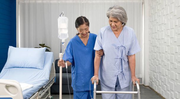Pfleger Arzt dienen physikalische Therapie für ältere Patienten zu üben und üben das Gehen auf Rollator oder Stock. Junge asiatische Krankenschwester im Pflegeheim kümmern behinderte Seniorin. - Foto, Bild
