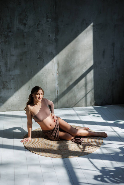 Young pretty pregnant woman in skirt posing in studio and stroking her belly. Pregnant pregnant woman. Happy pregnancy. - Photo, Image