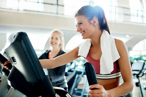 Shes setting the pace. attractive young women working out on treadmills at the gym - Фото, изображение