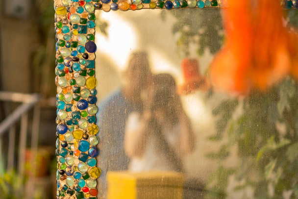 Szczęśliwa para turystyczna rejestruje rozmyte lustro Selfie z kolorowym szkiełkiem żwirowym w lustrze miejskim. - Zdjęcie, obraz