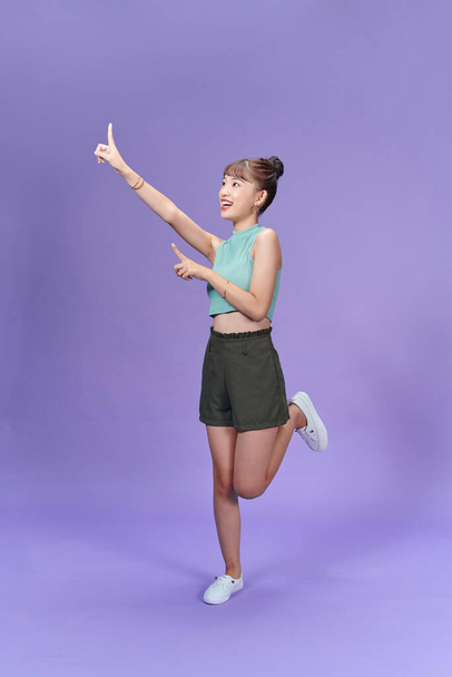 Full length image of young Asian woman posing on purple background - Fotó, kép