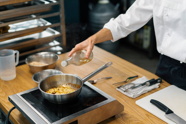 professzionális konyhafőnök karamellizáló gyümölcs zabpehely serpenyőben elkészítése reggeli egészséges étel koncepció - Fotó, kép
