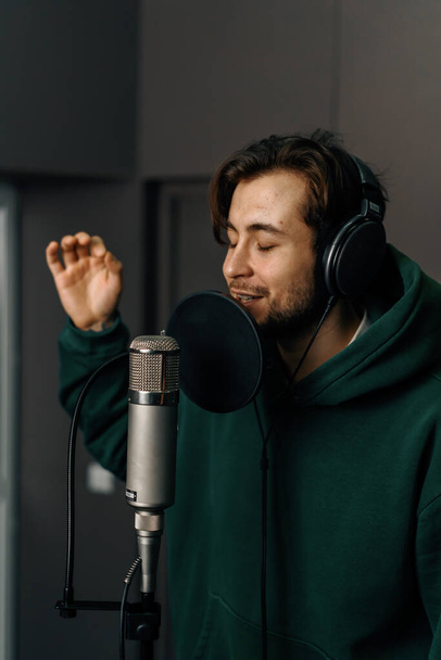 cantante rap con microfono cuffie registrare emotivamente nuova canzone in studio di registrazione professionale - Foto, immagini