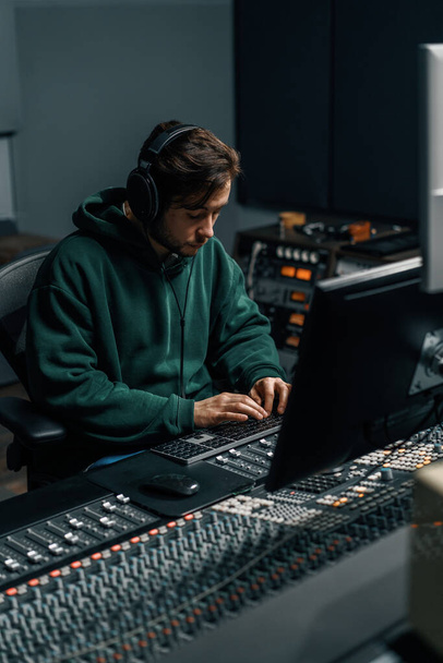 Sound engineer working in home music studio with monitors and equalizer screen mixing and mastering tracks - Fotoğraf, Görsel