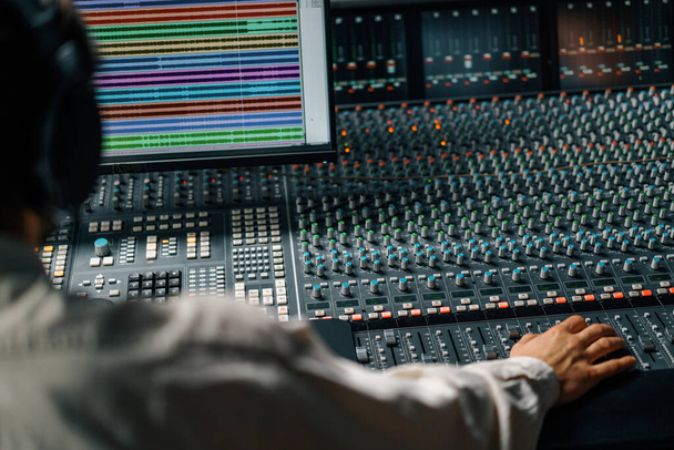 Sound engineer used digital audio mixer Sliders Engineer presses key Control panel Recording studio technician - Zdjęcie, obraz