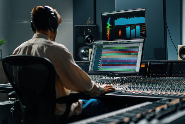 Tontechniker arbeitet im Musikstudio mit Monitoren und Equalizer-Screen-Mixing und Mastering-Tracks - Foto, Bild