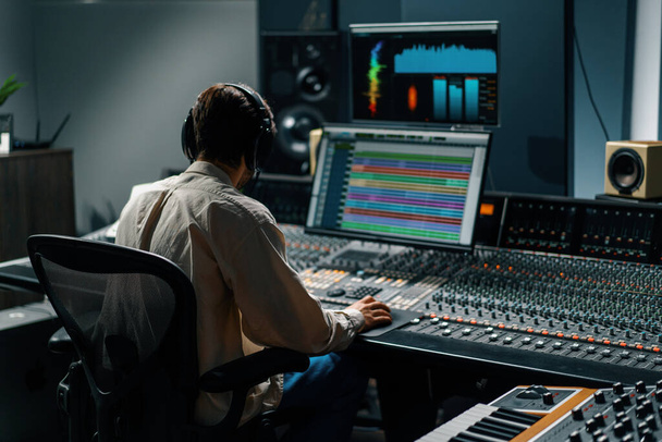 Ingegnere del suono che lavora in studio musicale con monitor e schermi equalizzatori mixando e masterizzando tracce - Foto, immagini