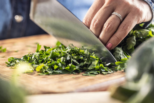 Green fresh parsley cut on a wooden board by a sharp knife. - Foto, immagini
