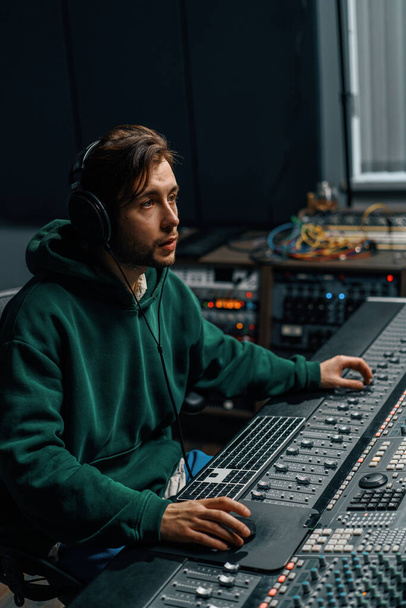 Sound engineer working in music studio with monitors and equalizer screen mixing and mastering tracks - 写真・画像