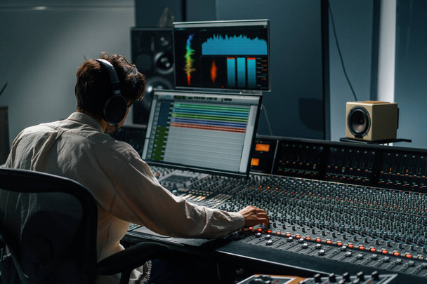 Μηχανικός ήχου που εργάζεται σε στούντιο μουσικής με οθόνες και equalizer μίξη οθόνης και mastering κομμάτια - Φωτογραφία, εικόνα