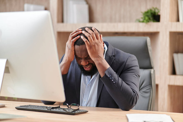 Stressful Job. Stressed African Businessman At Worckplace Touching Head Having Problem At Workplace Sitting In Modern Office. Crisis And Entrepreneurship Business Issues, Headache Concept - Φωτογραφία, εικόνα