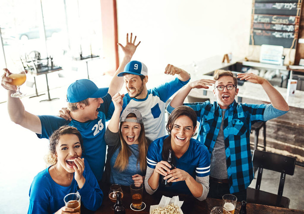 Les amis sont un must le jour du match. un groupe d'amis qui applaudissent en regardant un match de sport dans un bar - Photo, image
