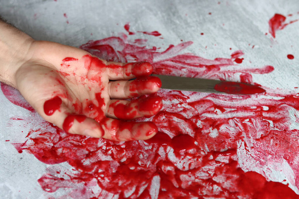 Hand mes op bloederige rommelige achtergrond met kopieerruimte. Zelfmoord Moordzaken Misbruik Domestic killing concept. Bloedige hand met een mes met bloed..  - Foto, afbeelding