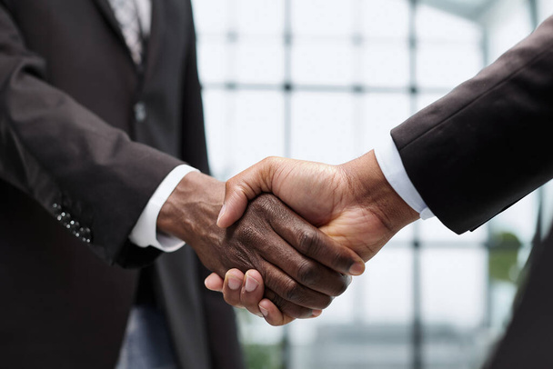 young businessmen shaking hands in the office close-up - Foto, Imagem