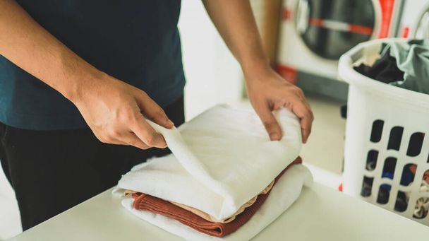 Mąż domu z koszem i brudne pranie myte ubrania w pralni wnętrza. pralka w pralni koncepcji sklepu biznesowego - Zdjęcie, obraz