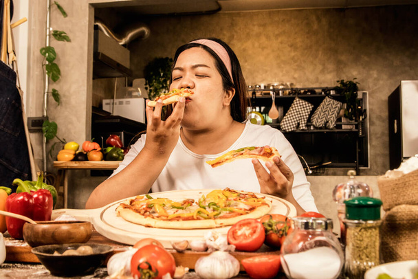 Hot shots of fat asian women who are obsessed with eating home cooked pizza. Delicious pizza that is pleasing to the palate and appetizing can be eaten together with both hands : Tasty fast food pizza - Fotografie, Obrázek