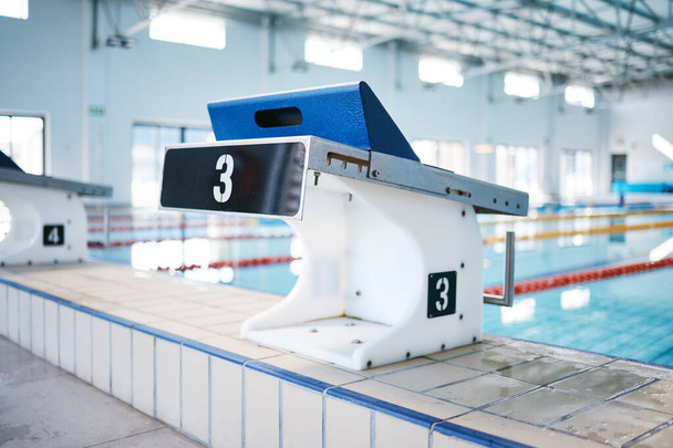 Start, platform and water sports with block at swimming pool for championship, jumping and race. Fitness, competition and wellness with lane in indoor arena for exercise, workout and training. - Foto, Imagem