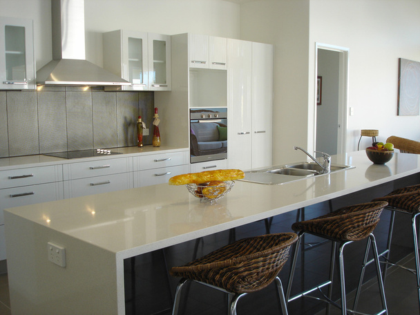 Spacious white open plan kitchen with breakfast bar - 写真・画像