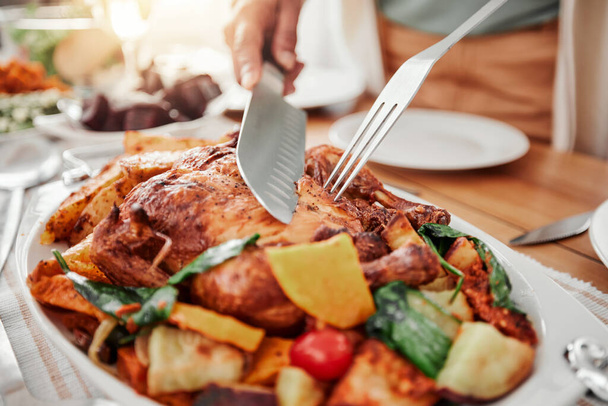 Food, cutting roast chicken on tablet and dinner, party or celebration with Christmas or thanksgiving holiday. Social event, closeup and carve protein with knife, gourmet meal and festive feast. - 写真・画像