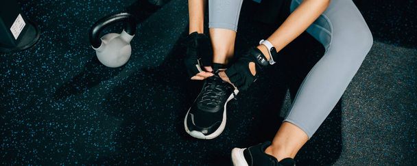 Detailní záběr na ženské nohy, jak si zavazuje tkaničky u bot, než začne cvičit. Výstřel je ideální pro fitness a zdravotní koncepce. - Fotografie, Obrázek