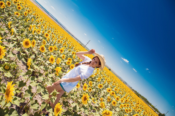 jonge mooie vrouw tussen zonnebloemen - Foto, afbeelding