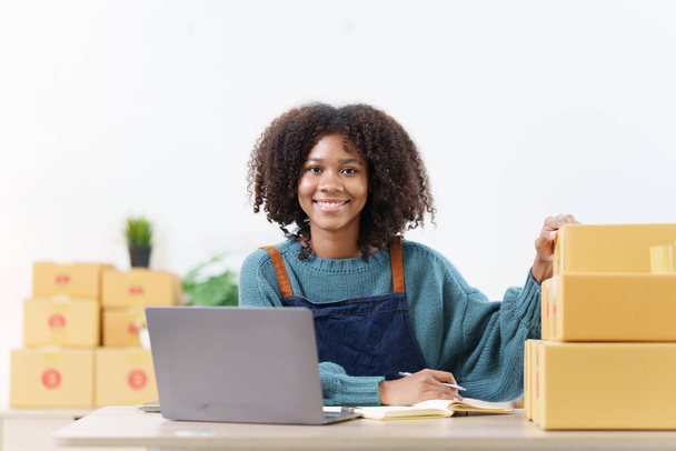American African entrepreneur smile and checking online order. Successful SME entrepreneur concept. - Fotó, kép