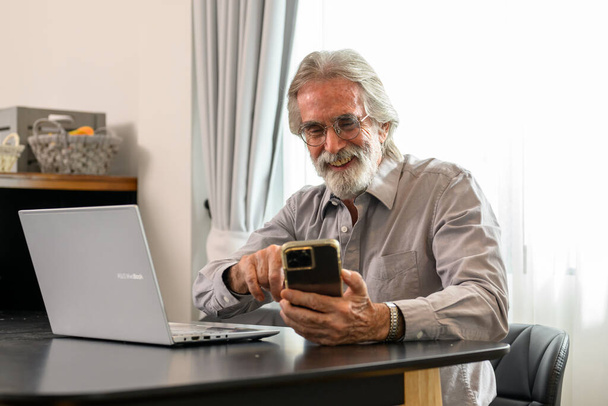 Senior grandfather using laptop and smart phone at home, Happy retirement people relaxing and resting at home, Healthy and happy senior people concept - Photo, Image