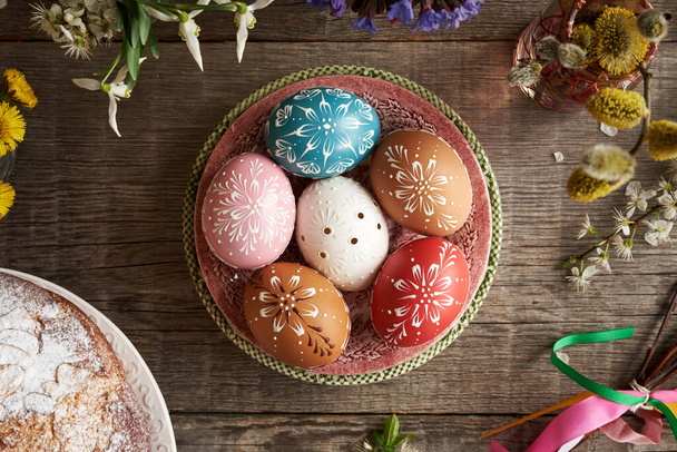 Top view of Easter eggs decorated with wax with flowers and mazanec - Czech sweet Easter pastry, top view - Photo, image