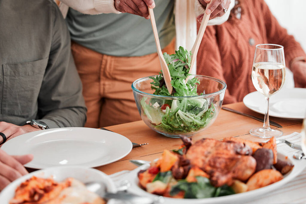 Τραπέζι φαγητού, οικογένεια και φαγητό, φαγητό ή γιορτάζουμε μαζί. Σαλάτα, πεινασμένοι και άνθρωποι που τρώνε με γκουρμέ πιάτα, απολαμβάνοντας σπιτική κουζίνα και μοιράζονται την κουζίνα κατά τη διάρκεια του δείπνου στο σπίτι. - Φωτογραφία, εικόνα