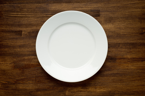 Empty white plate on wooden table - Zdjęcie, obraz