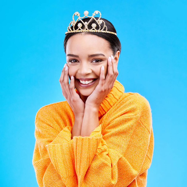 Happy, crown and portrait of woman in studio for celebration, princess and party. Smile, beauty and fashion with female and tiara on blue background excited for achievement, winner and prom event. - Photo, Image