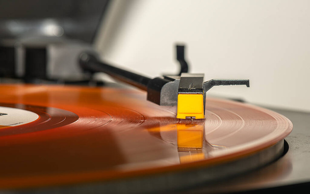 オレンジの長いレコードプレーヤーの針の上にホバーとしてメロディーの音を作ります. - 写真・画像