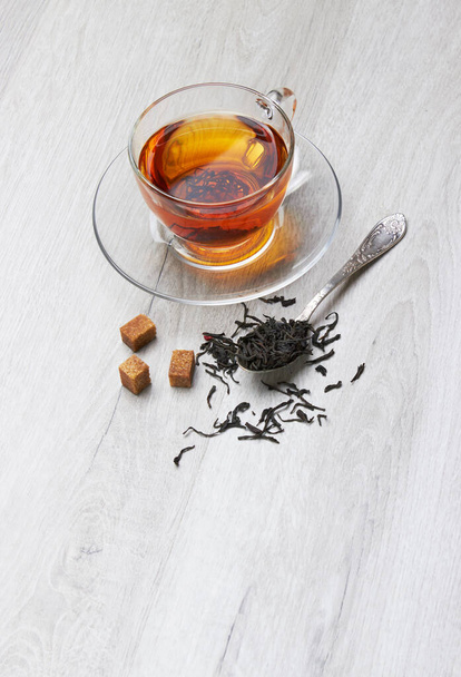 Cup of Tea and spoon, sugar, on a light wooden background - Φωτογραφία, εικόνα