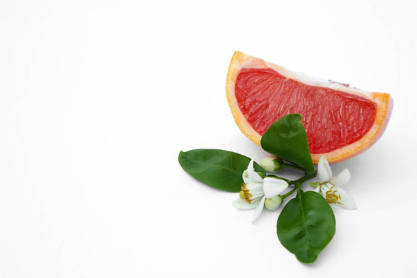 Cut fresh ripe grapefruit and green leaves on white background. Space for text - Foto, Bild