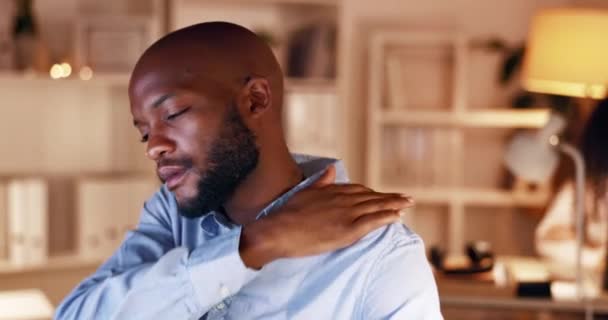 Black man, shoulder pain and stress at night in burnout, fatigue or discomfort from overworked at the office. Tired African businessman working late suffering from painful body, pressure or anxiety. - Footage, Video