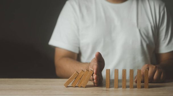 Man hand stopping the domino effect. Business risk management concept. business strategy. Stop loss for crisis management concept. - Photo, Image