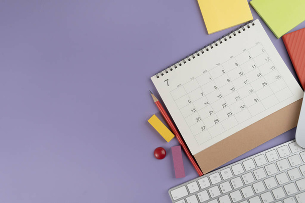 close up of calendar, keyboard and accessories on the purple table background, planning for business meeting or travel planning concept - Photo, image