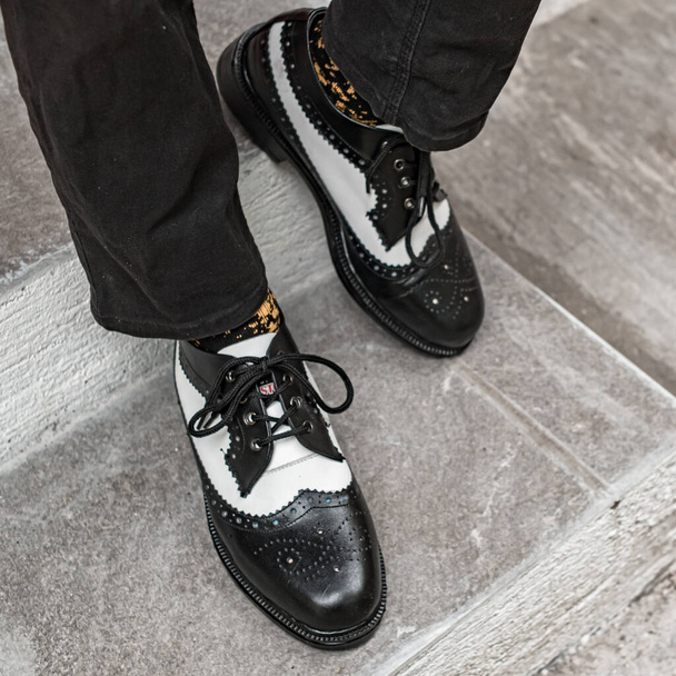 The young man wore a classic two-tone genuine leather brogue, vintage brogue wingtips that were shiny and ready to hang out on a sunny day. - Valokuva, kuva