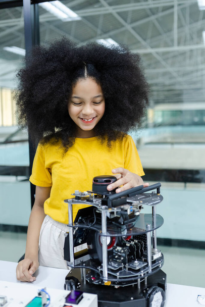 lapset tyttö afro kampauksen koulutus elektroninen pöydällä luokkahuoneessa. sähköisten innovaatioiden oppiminen tulevaisuuden tekoälyä varten. sähköjärjestelmän taitokoulutus. STEM-koulutuksen käsite. - Valokuva, kuva