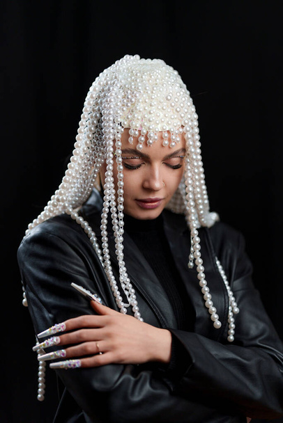 Estúdio retrato de uma mulher concentrada com fantasia traje com unhas falsas e uma peruca de pérola - Foto, Imagem