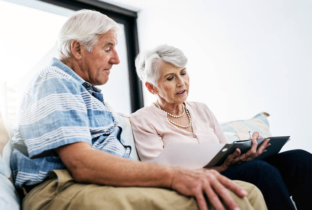 Was sagen die Zahlen? ein älteres Ehepaar, das zu Hause gemeinsam die Papierkram erledigt - Foto, Bild