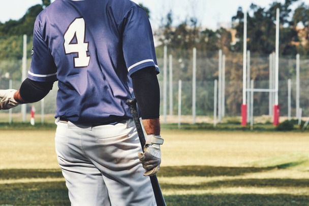 Zadní pohled baseballového hráče držícího pálku v týmové uniformě na hřišti - Fotografie, Obrázek
