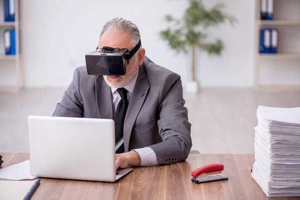 Stary pracownik korzystający z wirtualnych okularów w miejscu pracy - Zdjęcie, obraz
