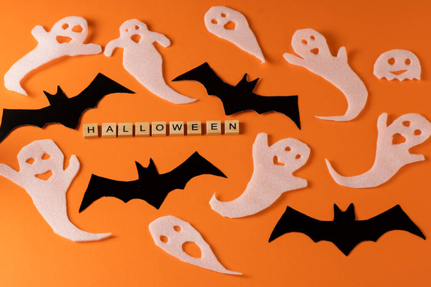 White ghosts and bat craft for Halloween party. Wrapping paper ghost on orange background top view. Cartoon creepy Whisper. DIY hand made. Set boo characters. Word wooden letter phrase. - Valokuva, kuva