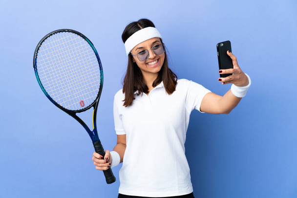 Молода жінка тенісистка над ізольованим тлом робить селфі
 - Фото, зображення
