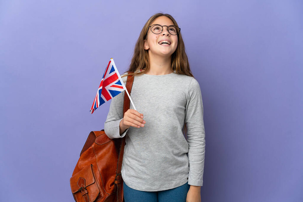 Child holding an United Kingdom flag over isolated background laughing - Photo, Image