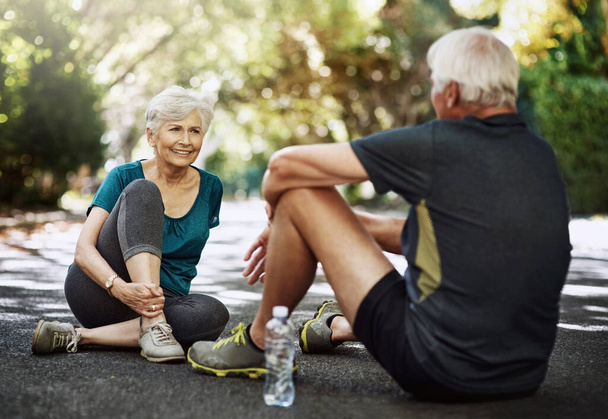 Healthy habits are vital, no matter your age. a senior couple taking a break while out for a run together - Foto, immagini
