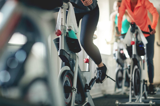 Obejmij moc roweru. kobiety ćwiczące na rowerach treningowych na spinningu na siłowni - Zdjęcie, obraz